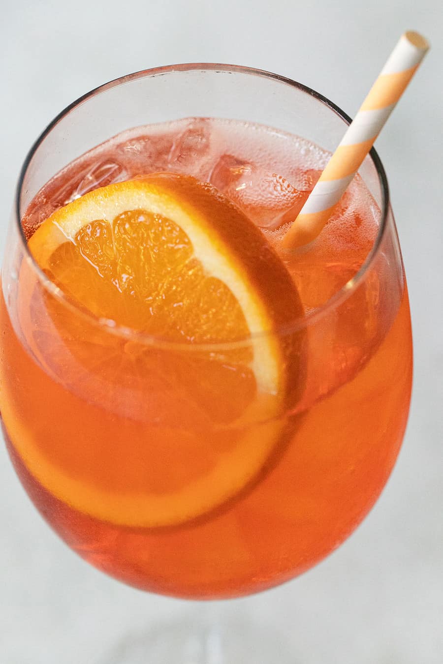 Aperol Spritz with a straw and orange slice