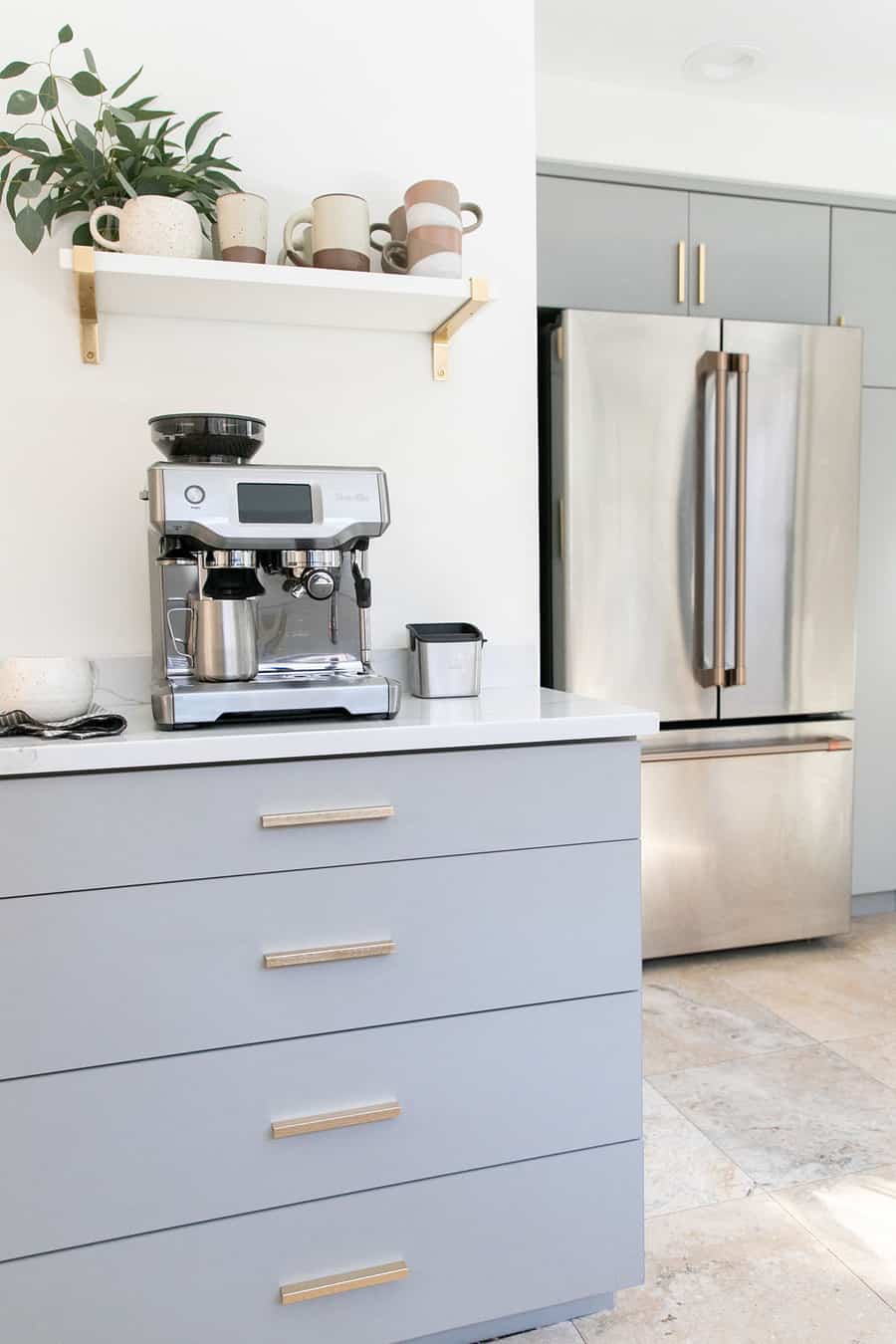 Gray kitchen cabins, gold pulls, cafe appliances and espresso maker 