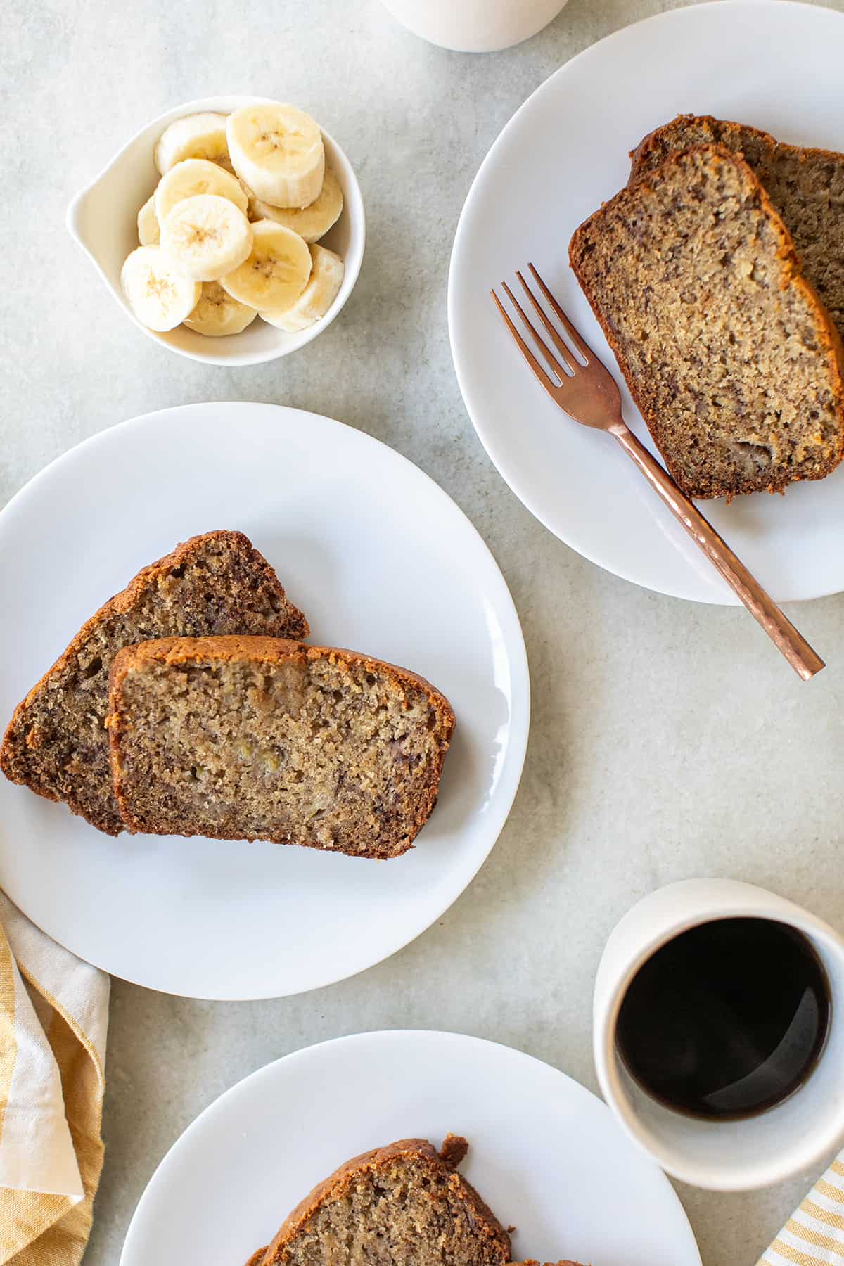 An easy banana bread recipe  on white plates with coffee