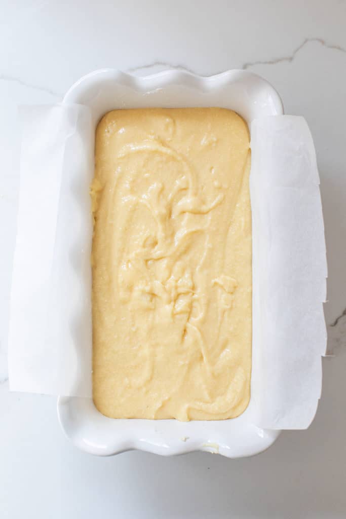 Pound cake in a loaf pan with parchment paper.