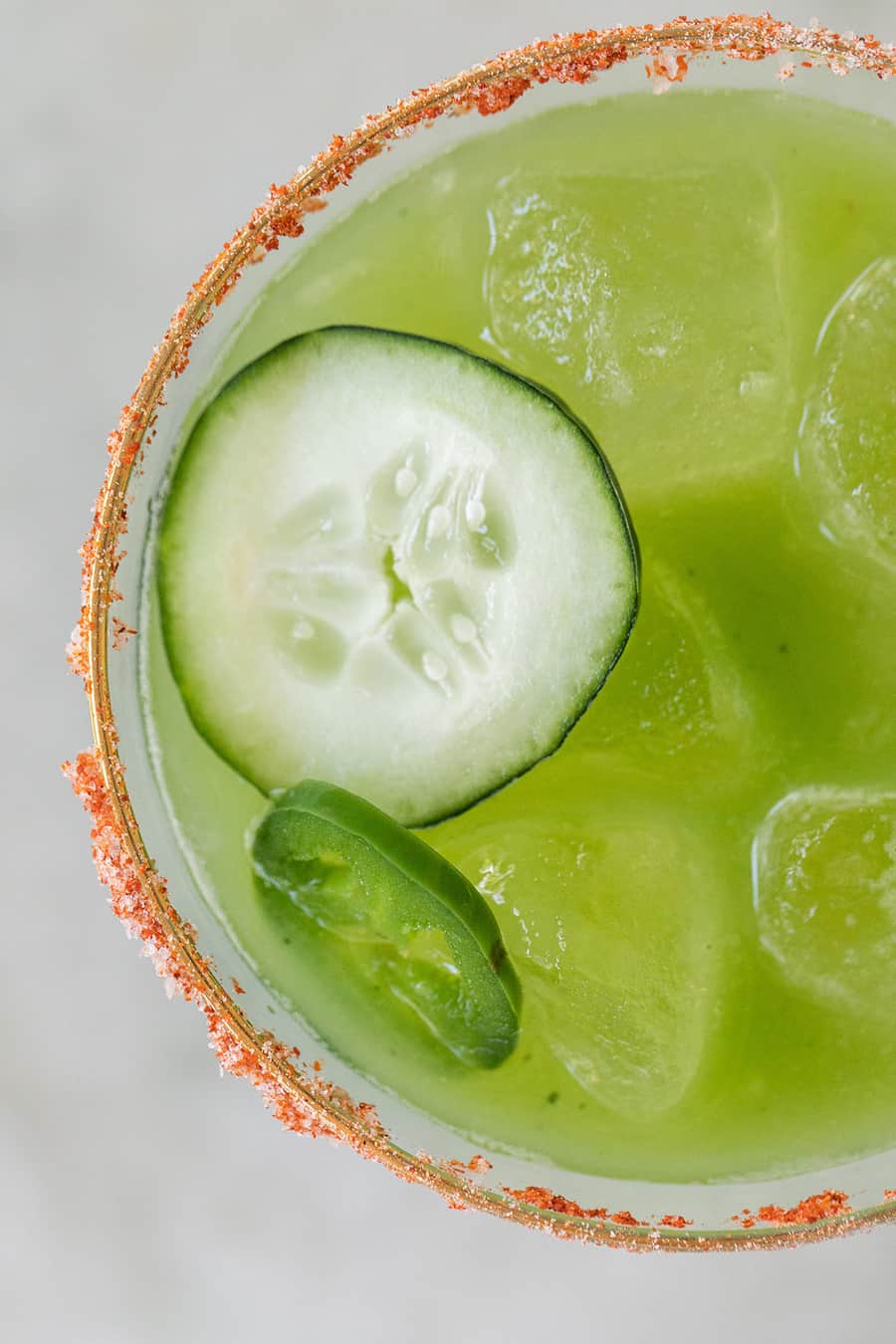 Spicy green cocktail with cucumber and a spicy rimmed glass