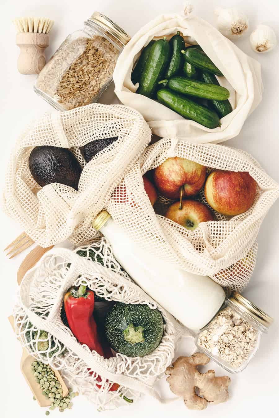 Zero waste concept. Eco bags with fruits and vegetables, glass jars with beans, lentils, pasta. Eco-friendly shopping, flat lay