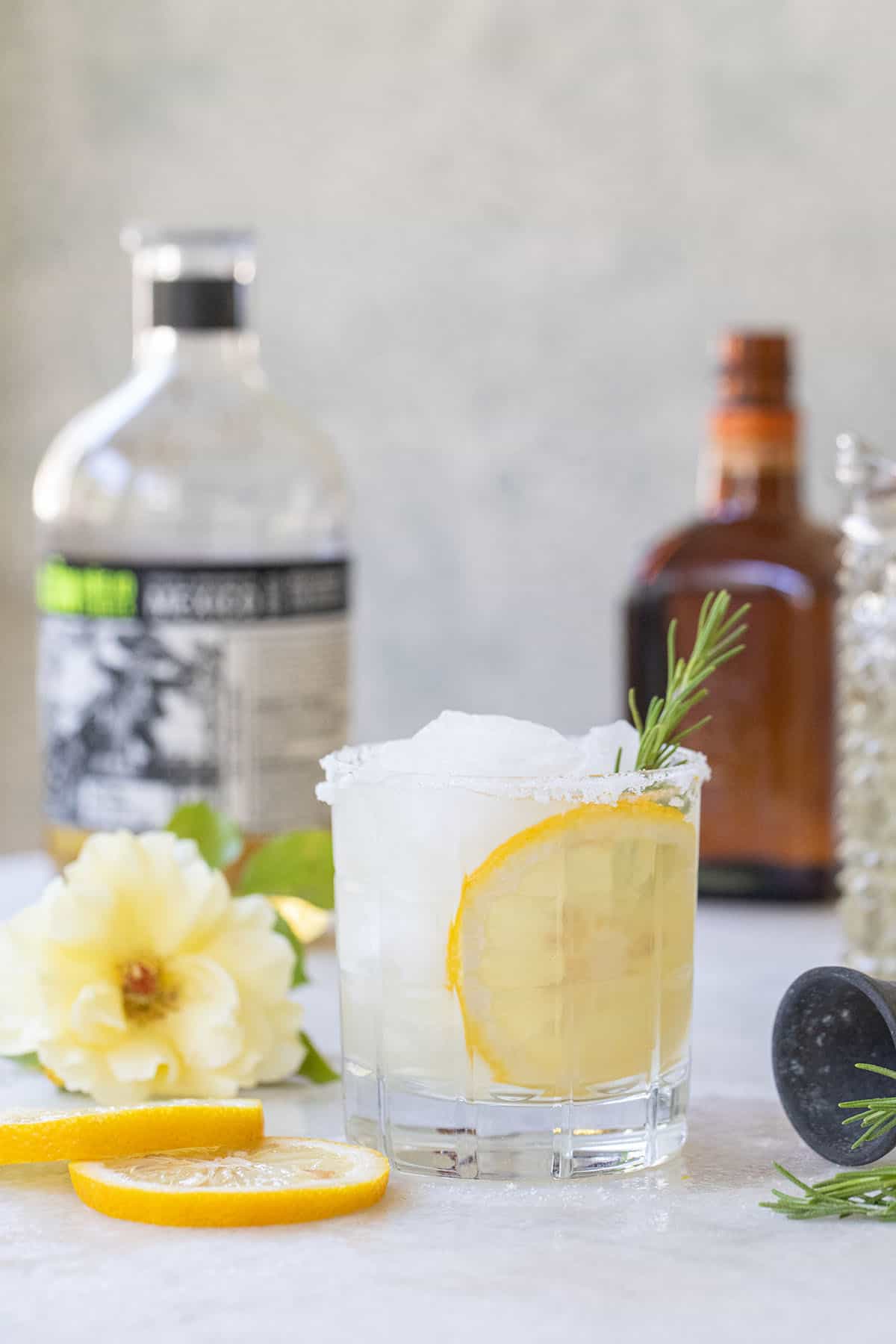 Lemon margarita recipe with lemon slice, rosemary and a salted rim.