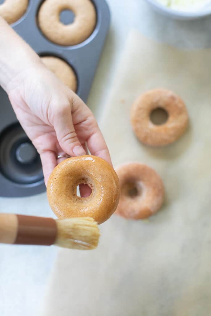 brushing donut with butter - brown sugar, reduced apple cider, cake donuts
