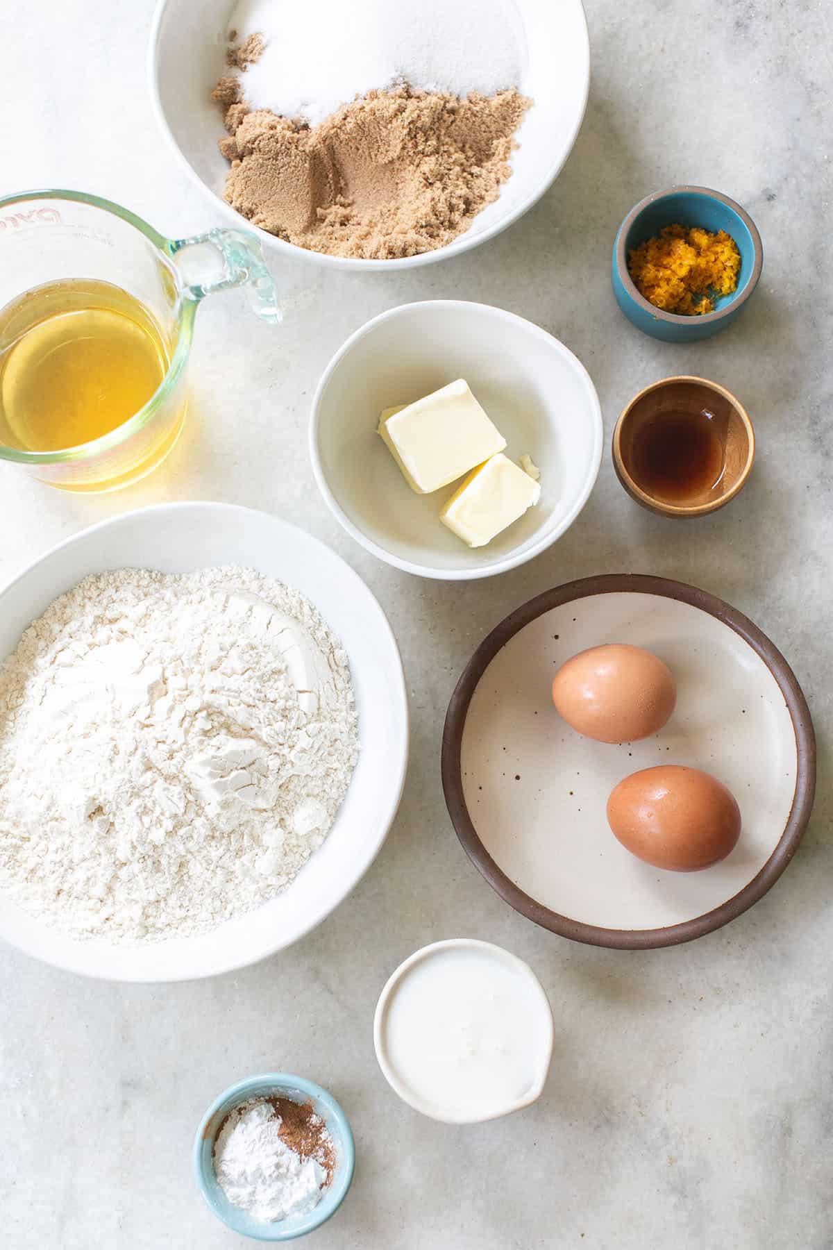 Flour, butter, eggs, buttermilk and vanilla in bowls to make donuts.