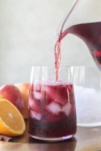 fall sangria pouring into a wine glass