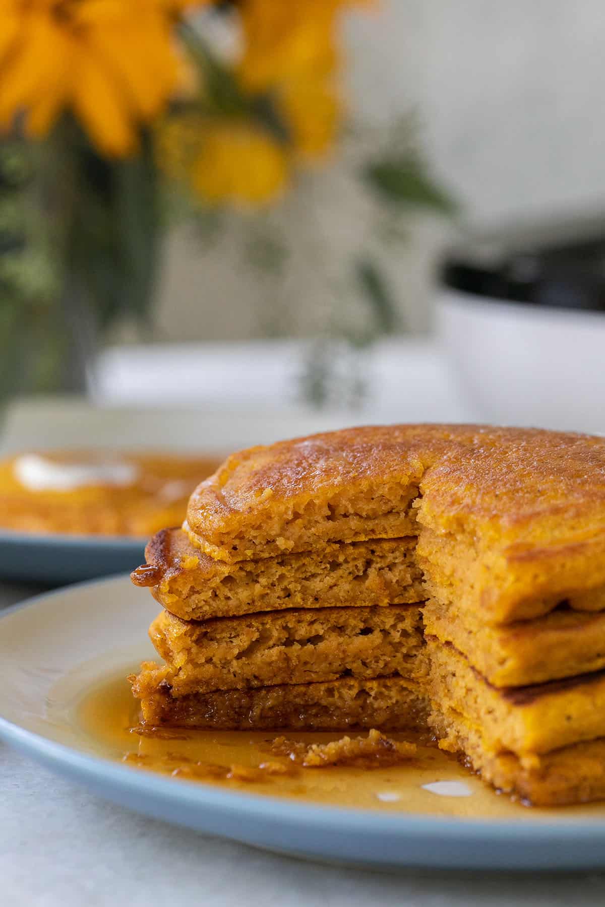 Slices taken out of pumpkin pancakes with syrup over them.