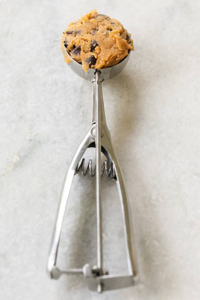 Cookie scooper with pumpkin chocolate chip cookie dough.