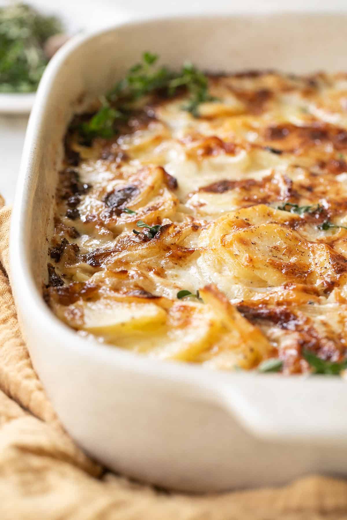 Cheesy Scalloped potatoes in a baking dish.