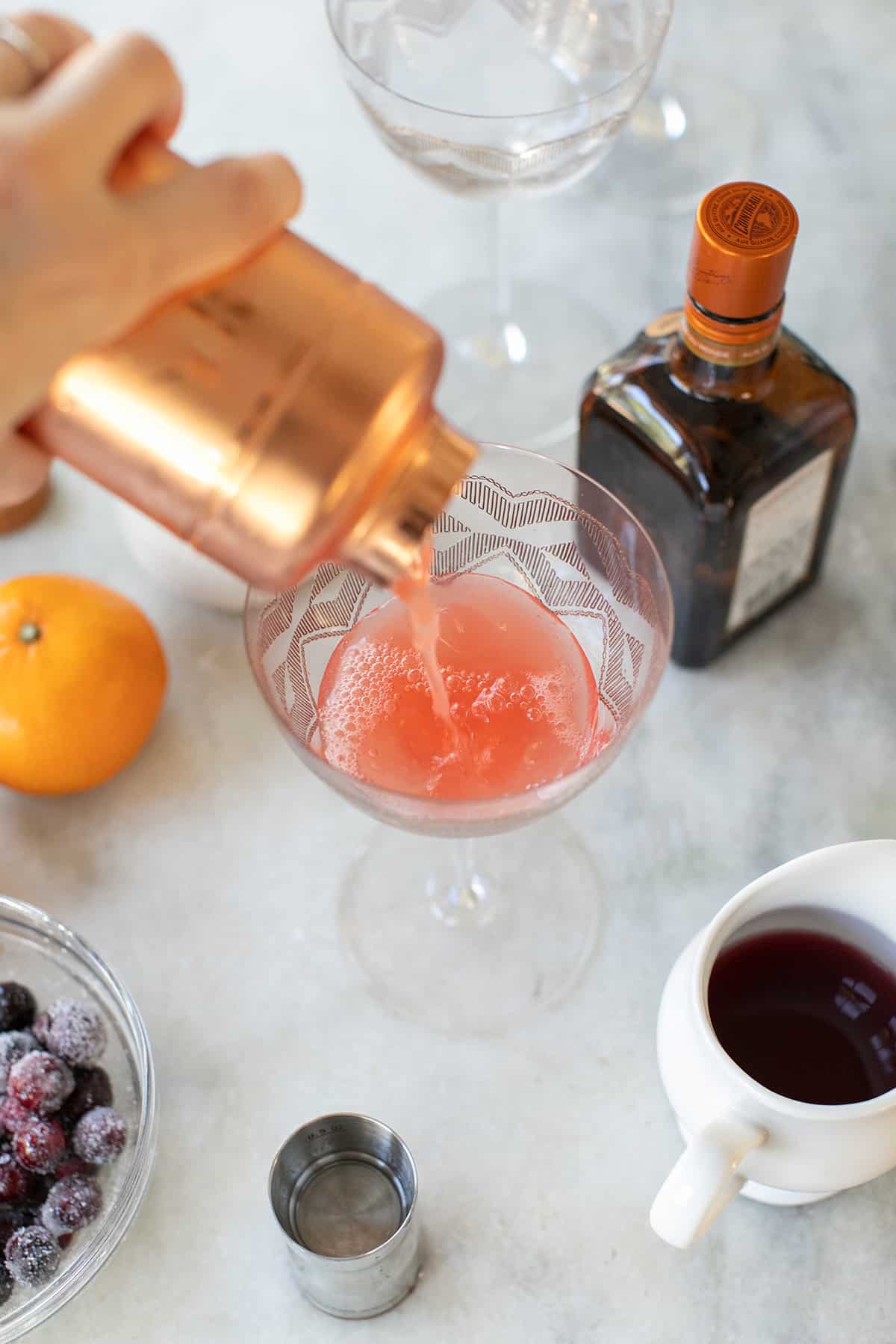 pouring a holiday cocktail into a glass