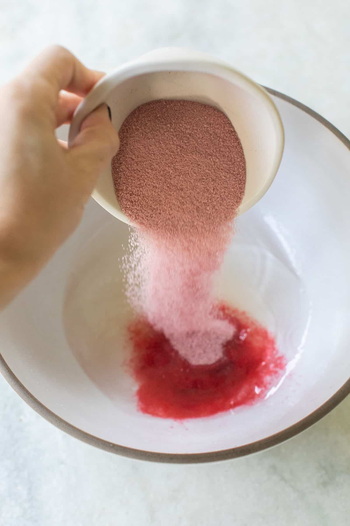 cranberry Jello pouring into gelatin - cranberry jello shots recipe, sugared cranberries, completely dissolved