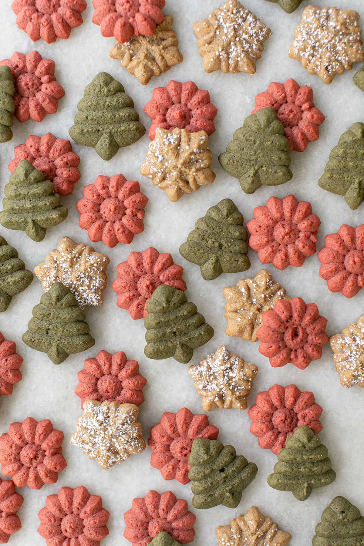 Colorful spritz cookies shaped as trees, snowflakes, and flowers. 