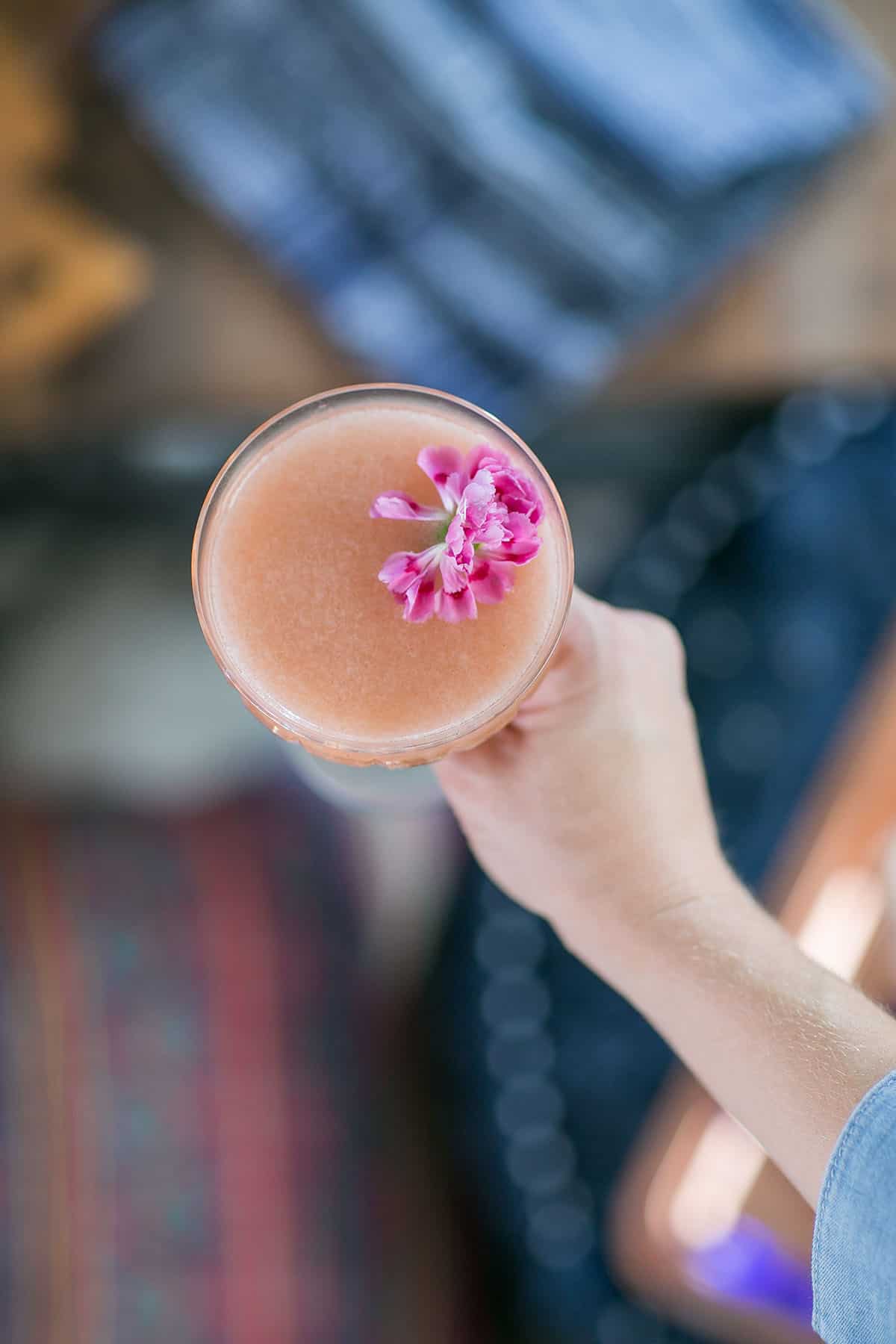 Pink gin and jam cocktail with a pink flower.