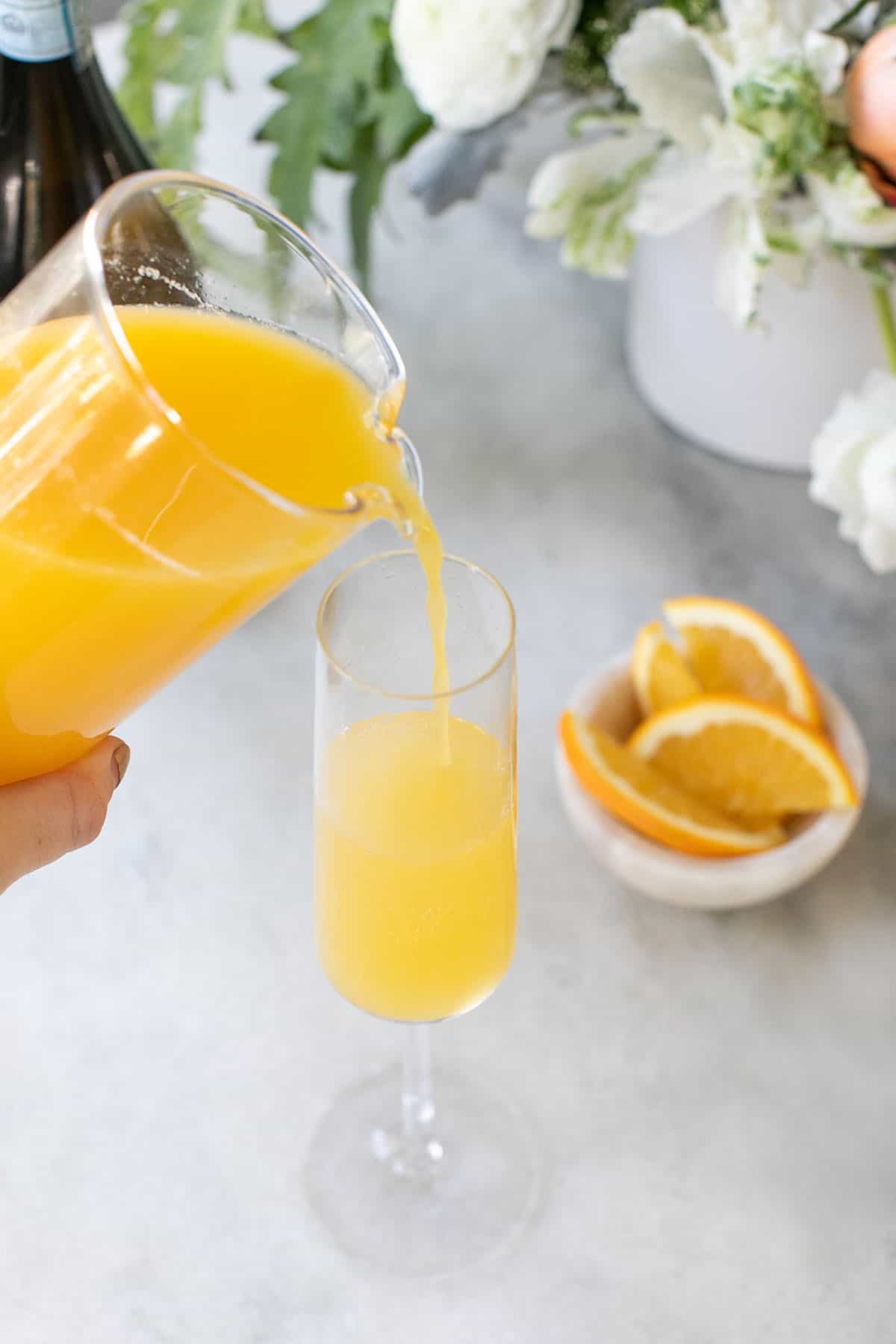 adding orange juice into a glass