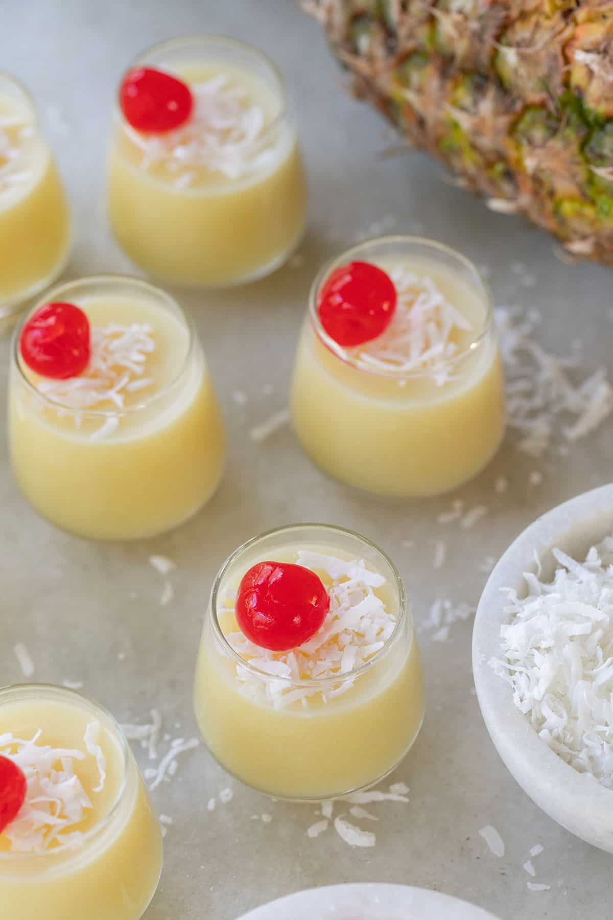 Pina colada jello shots with cherry and coconut over the top.