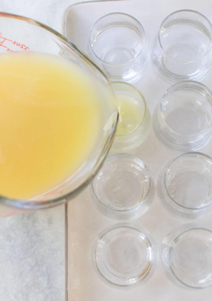 pouring pina colada jello shots into shot glasses