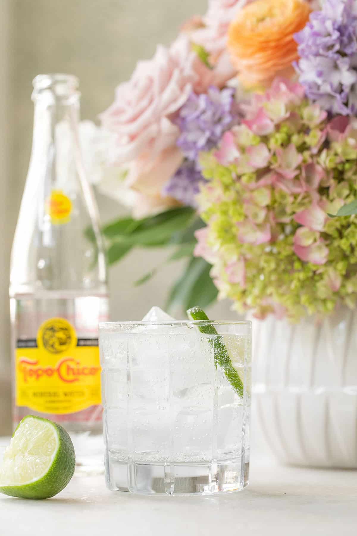 Topo Chico in a glass filled with ice with lime juice