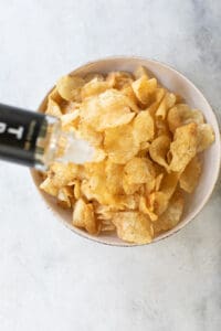 pouring truffle oil over potato chips