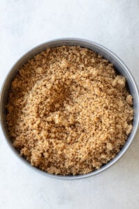 pressing graham cracker crust into a springform pan