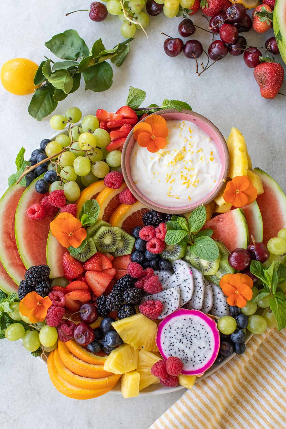 Easy fresh fruit platter with fruit dip, berries, sliced fresh fruit on a platter.