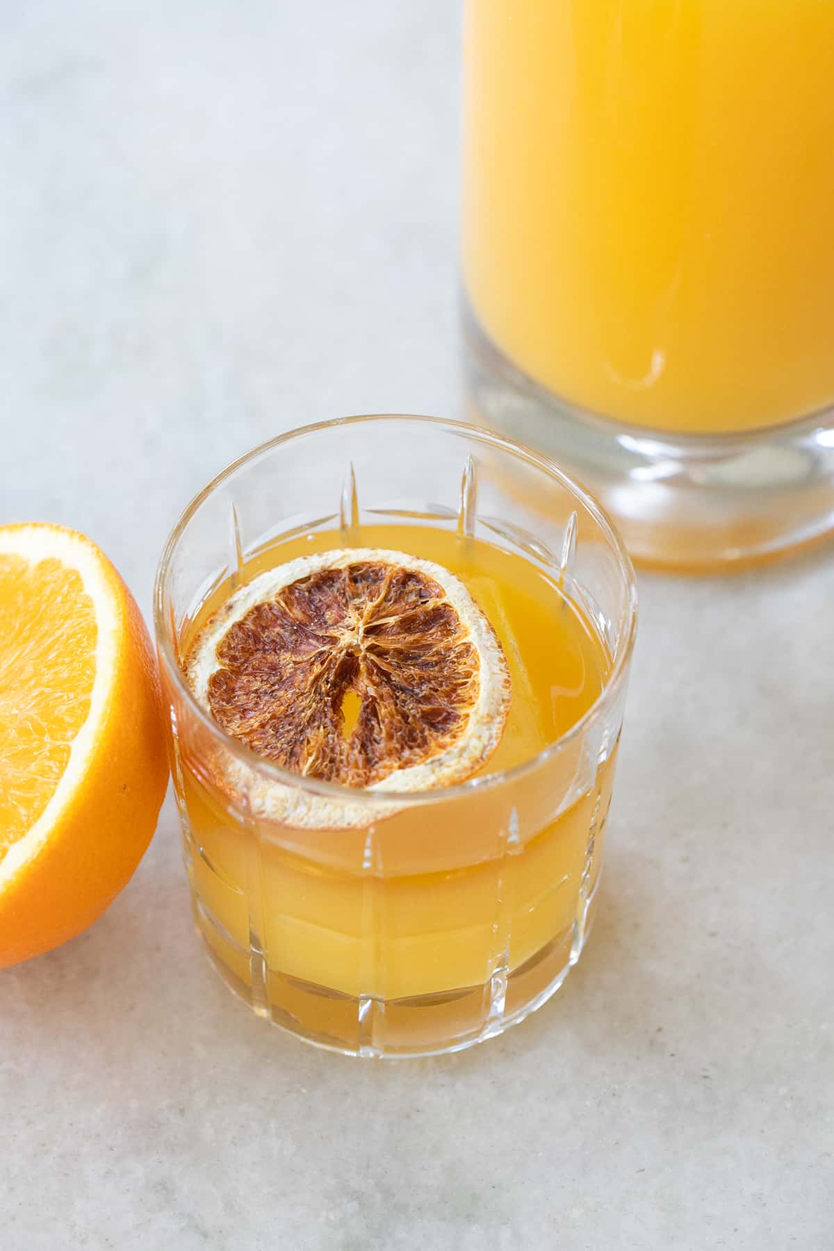 whiskey and orange juice in a glass with a dried orange slice