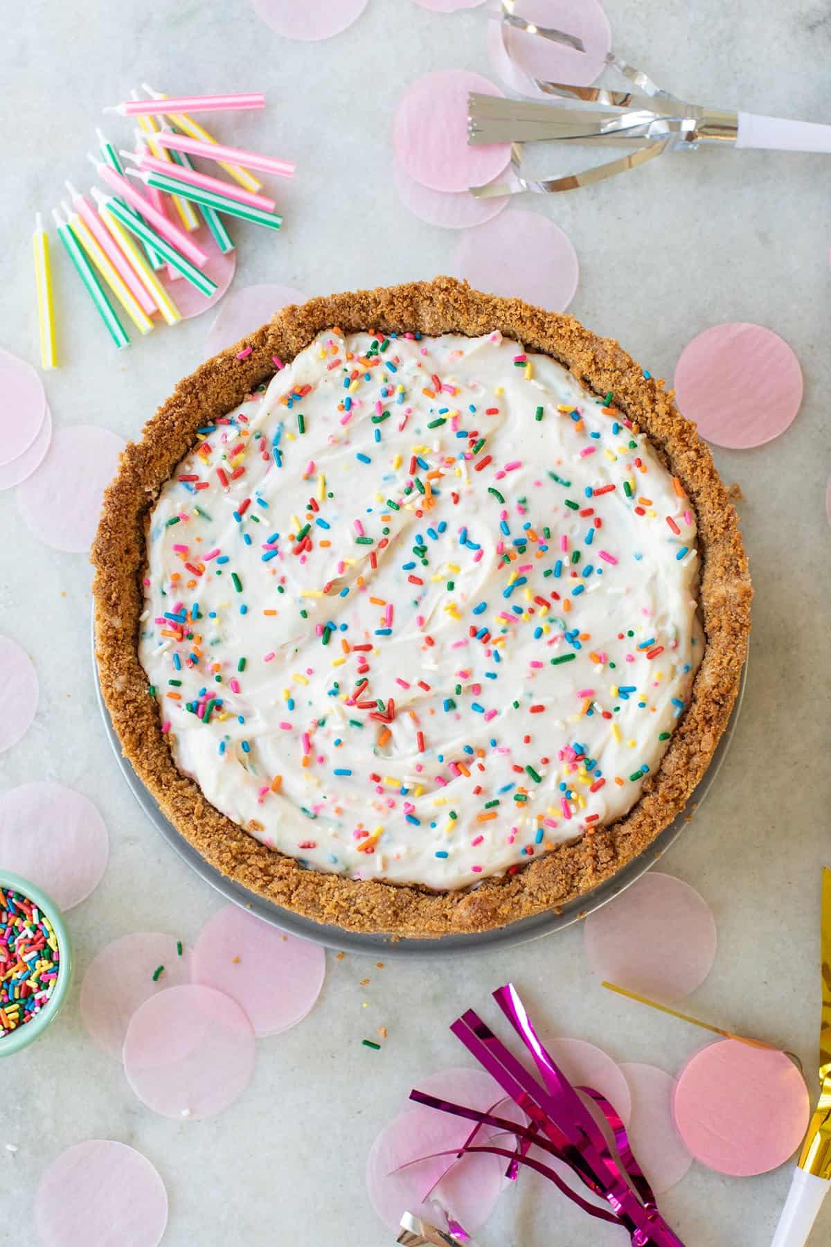 Birthday cheesecake with graham cracker crust and sprinkles.