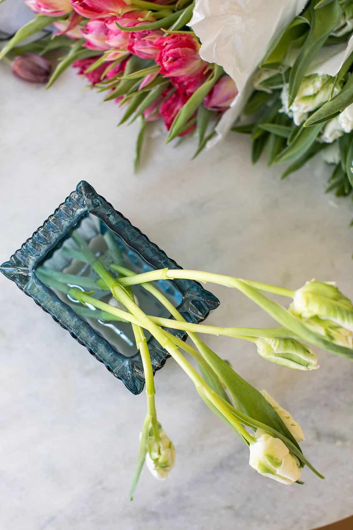 arranging tulips in a blue vase