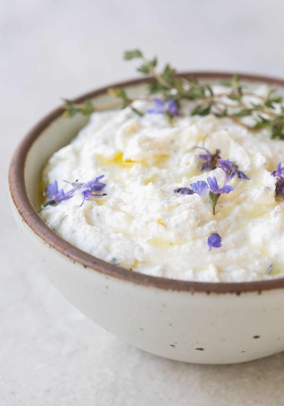 Creamy whipped goat cheese with olive oil drizzled over the top.