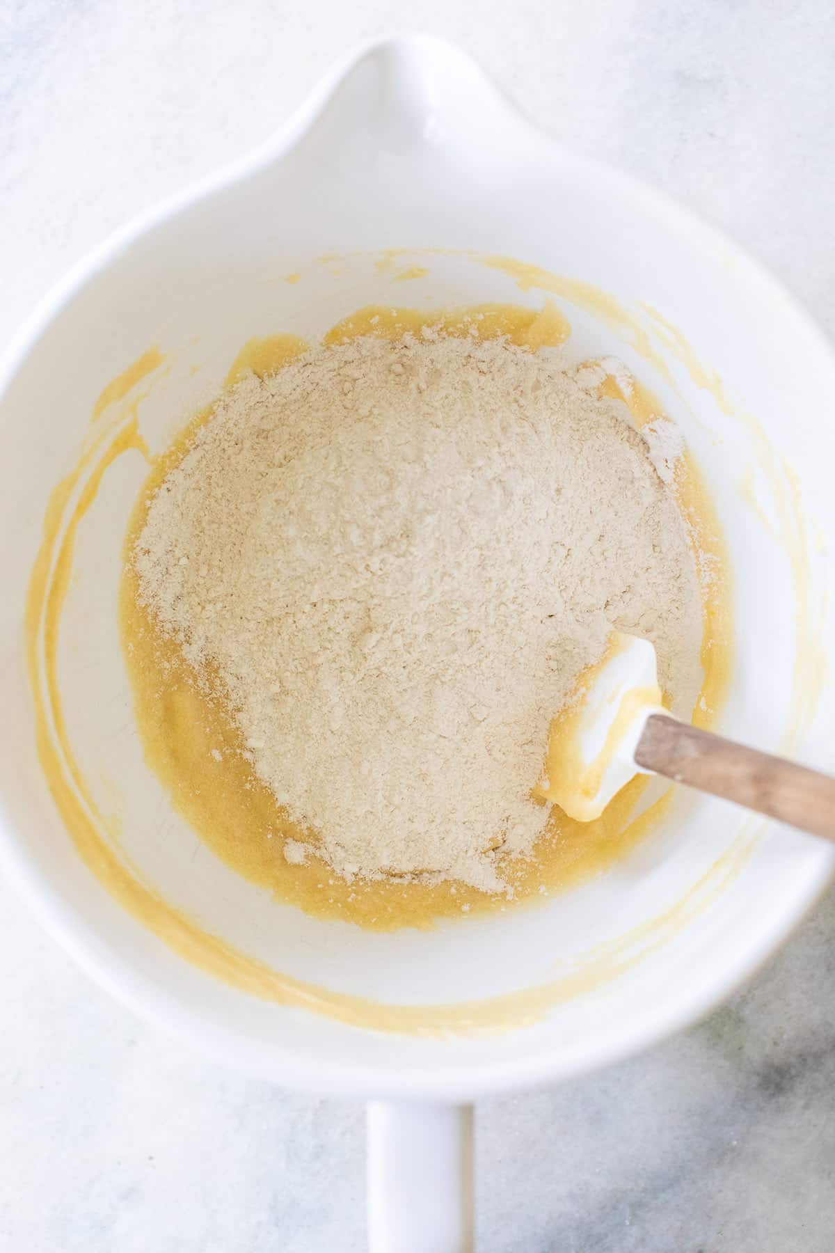mixing dry ingredients with wet ingredients to make vanilla brownies
