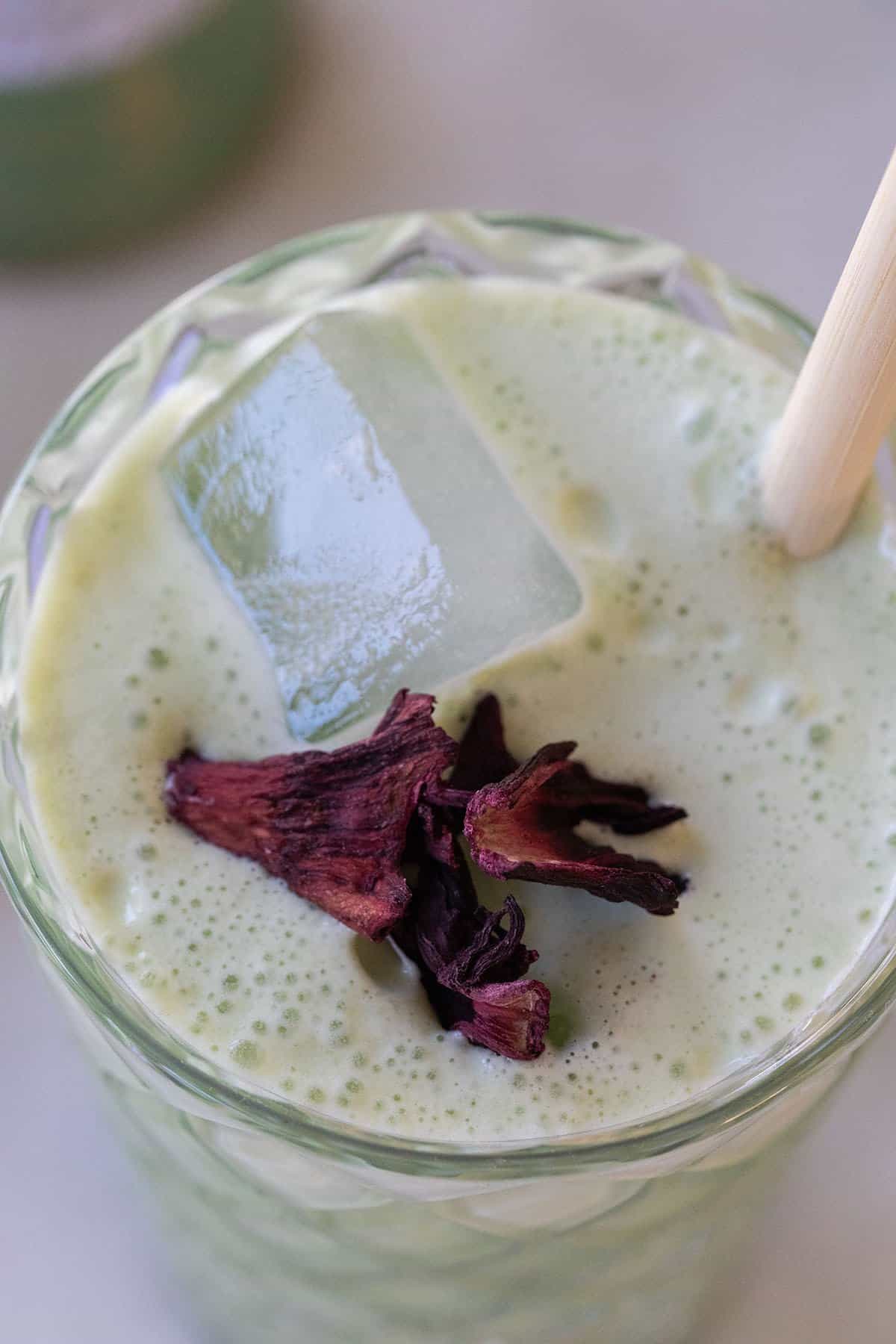 matcha latte, ice cubes and dried flower