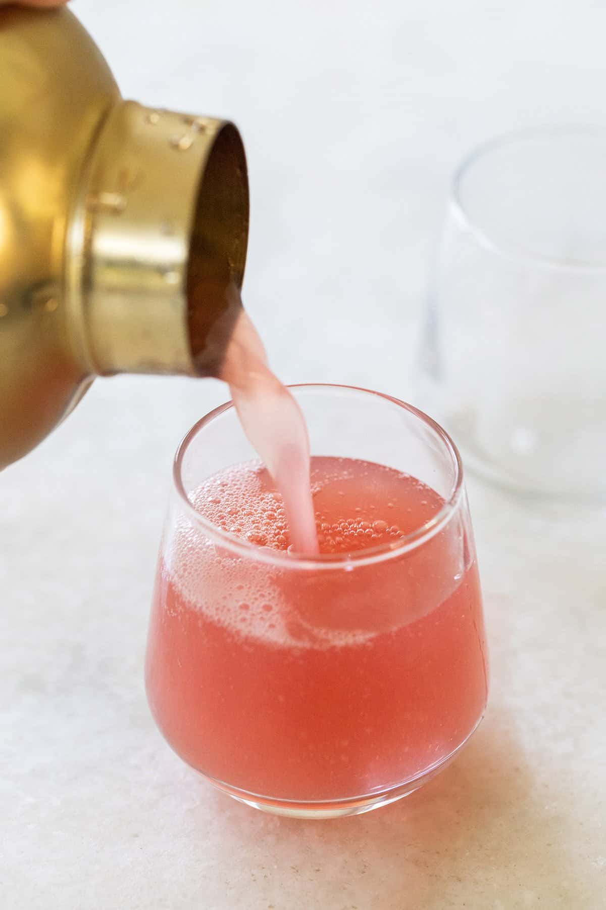 Pouring a jolly rancher shot into a shot glass.