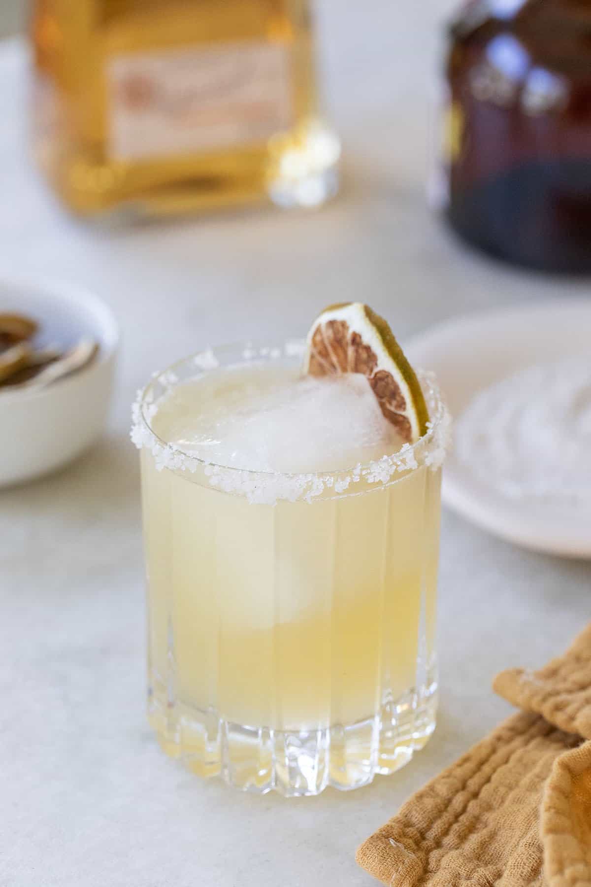 golden margarita with dried lime garnish.