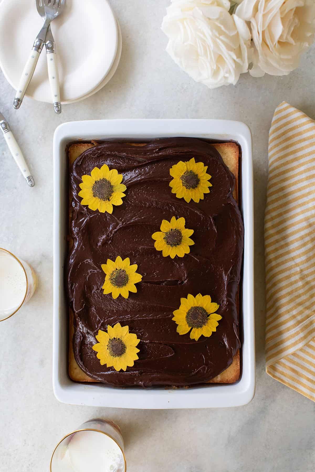 The best buutermilk cake recipe with chocolate frosting and edible flowers on the top