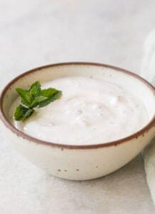 garlic dip in a small bowl with mint