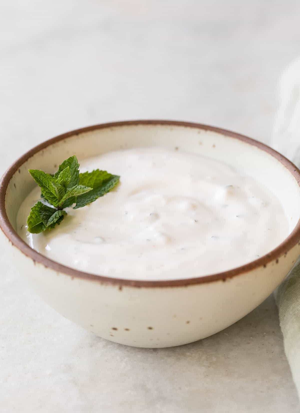 garlic dip in a small bowl with mint
