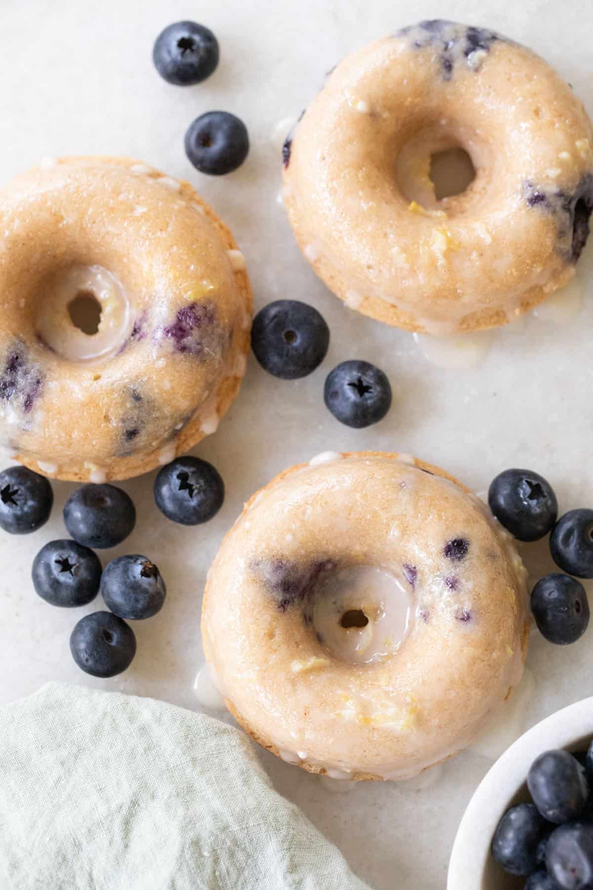 Baked blueberry donuts with glaze and lemon zest.