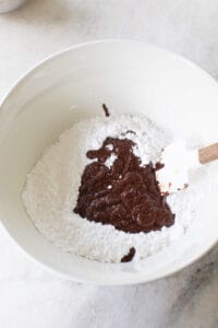 making chocolate frosting with powdered sugar and melted chocolate