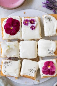 lavender cake cut into squares and decorated with edible flowers