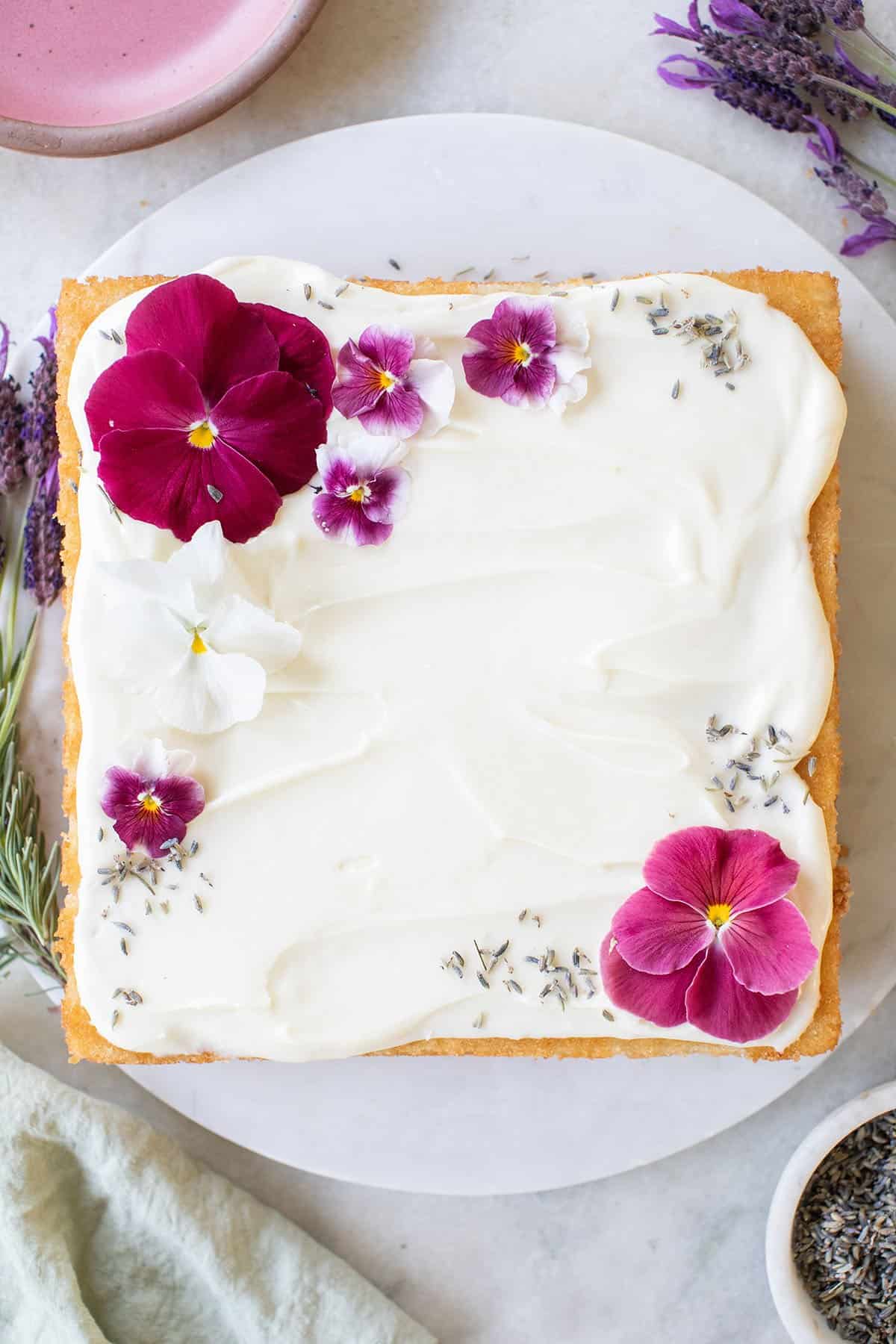 lavender sheet cake with frosting and edible flowers