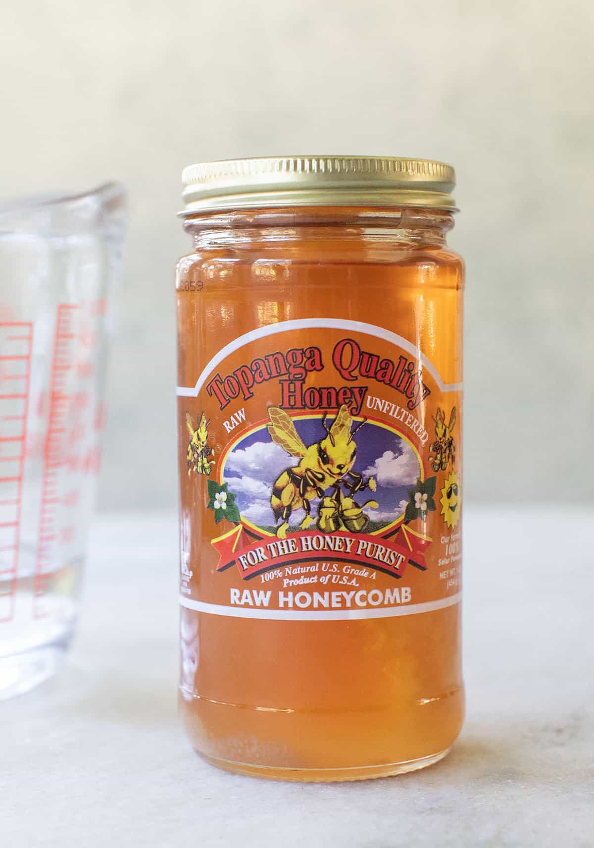 A jar of local raw honey is used to make it into liquid honey.