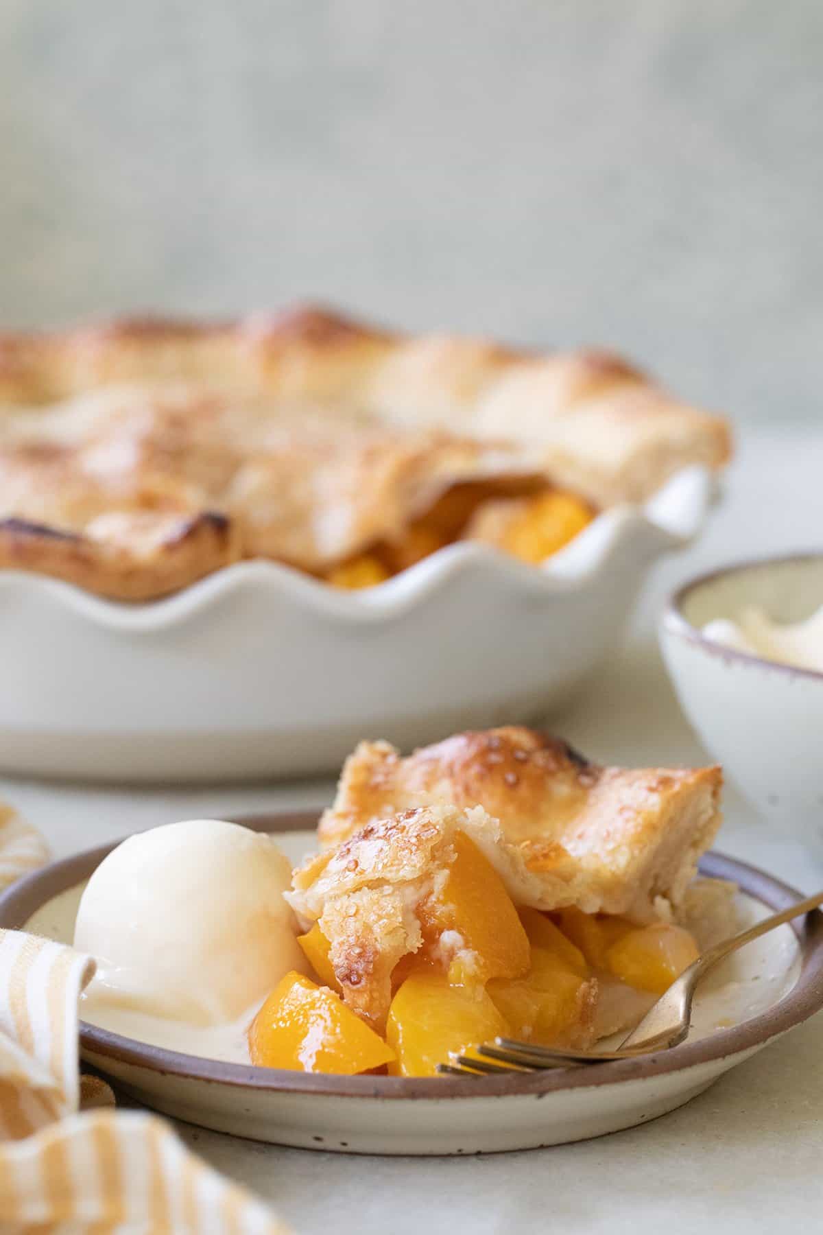 Slice of the best canned peach pie with a buttery pie crust. 