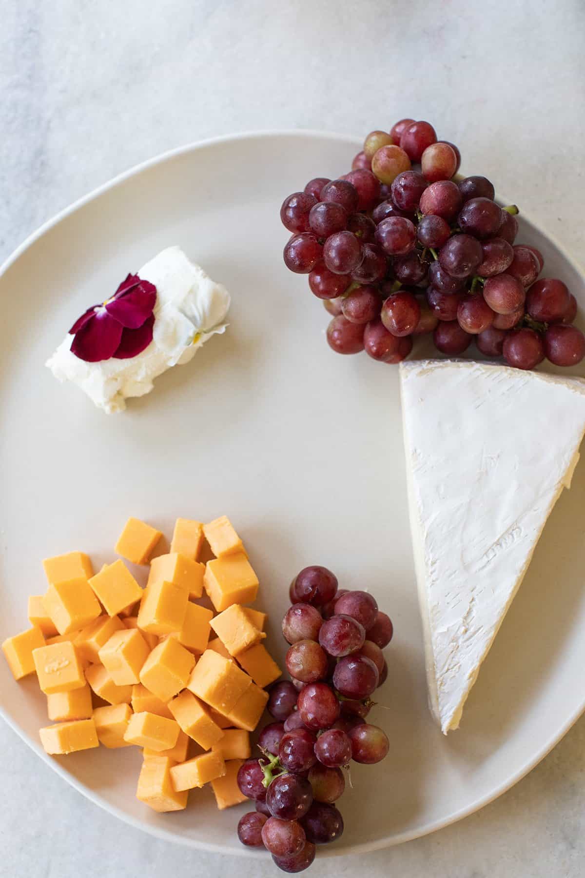 grapes and cheese on a round platter