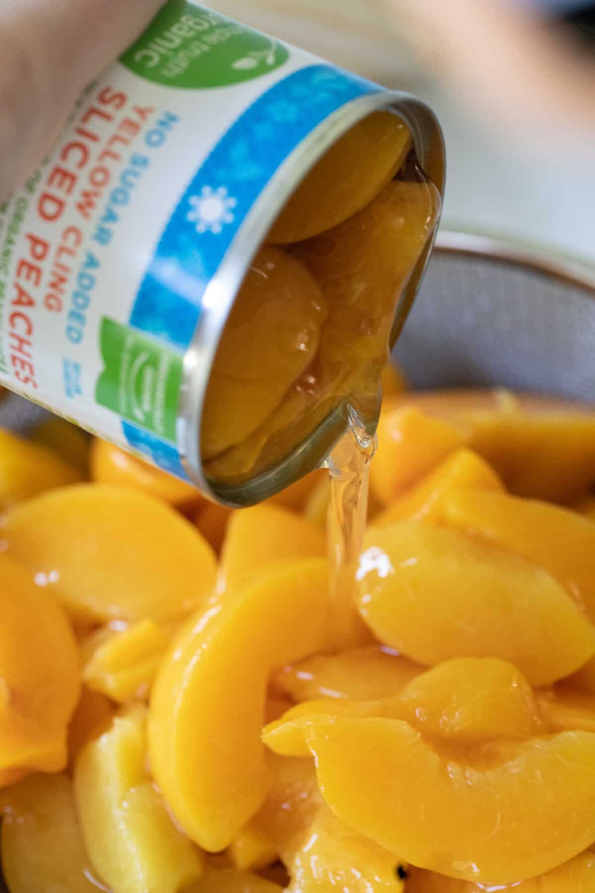 pouring organic no-sugar added peaches into a strainer