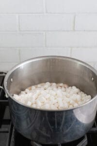 adding marshmallows into a large pot