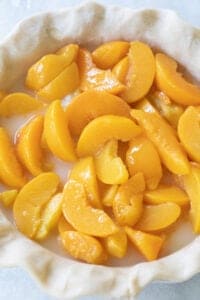 canned peaches in a prepare pie dish