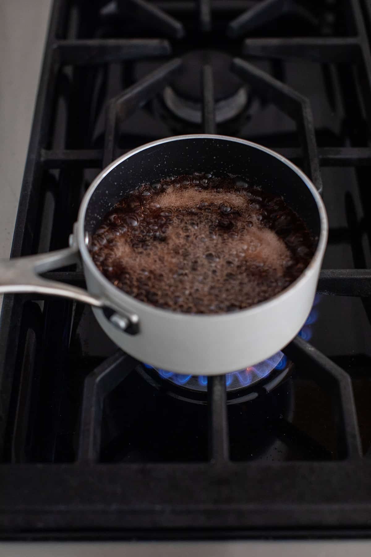 Grenadine syrup boiling in a small pot.