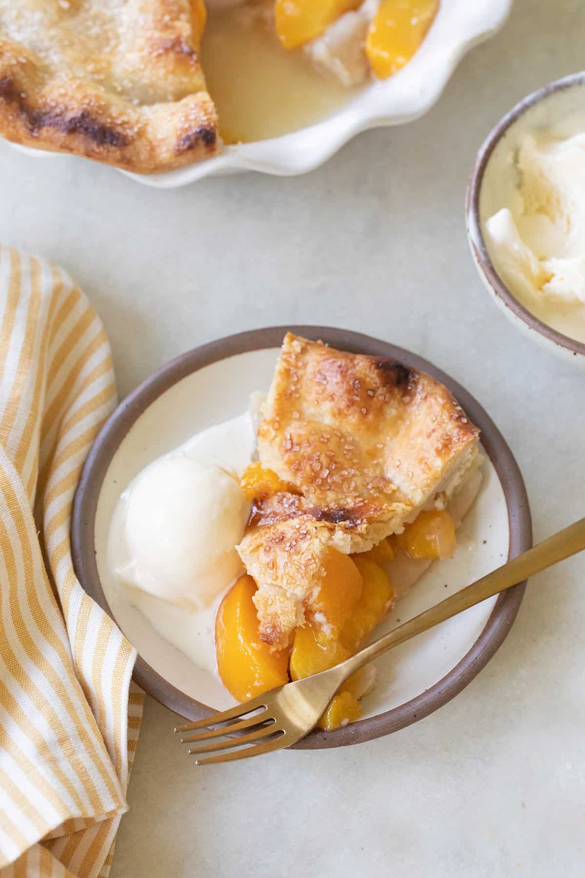 slice of peach pie with vanilla ice cream