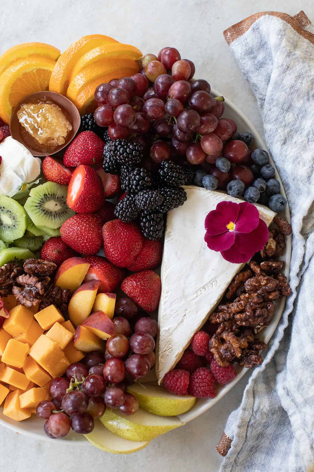 Brie cheese with candied walnuts, grapes, pears, raspberries and sliced kiwis.