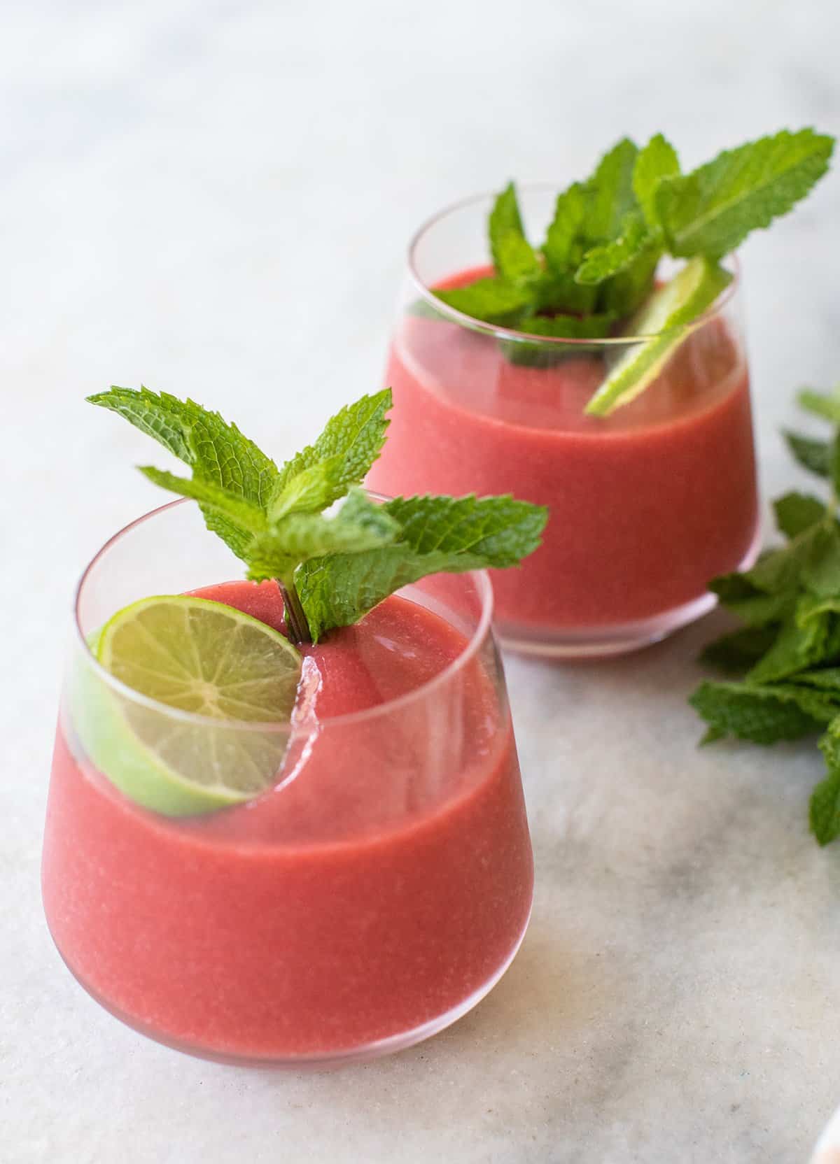 Frozen strawberry daiquiri in glasses with fresh mint.