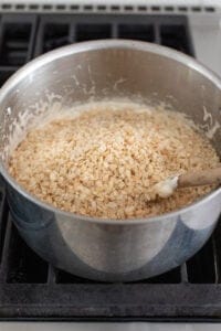 stirring rice krispies to the pot